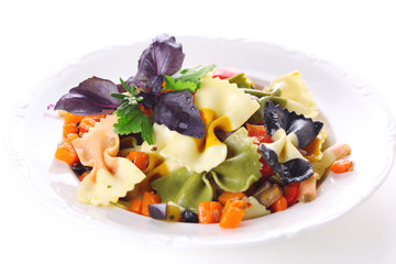 Pasta farfalle with vegetables on white plate.