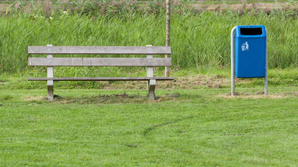 Park bench and blue trash can
