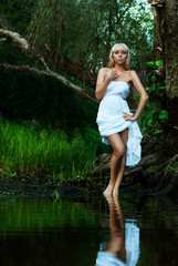 Blond Summer Girl in a forest river