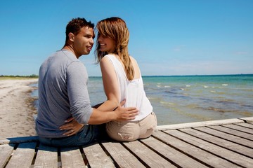 Attractive Couple Sitting on a Pier