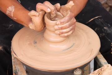 hands of potter, creating an earthen jar on the circle