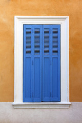 Mediterranean window with closed shutters.