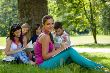 Fototapeta na wymiar Students studying on meadow in park teens