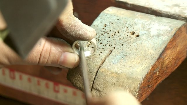 Goldschmied feilt Ring
