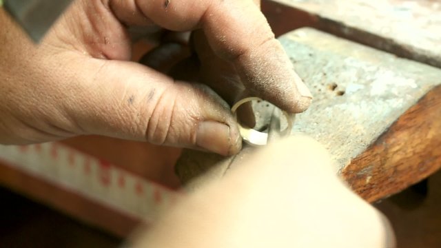 Goldschmied feilt Ring