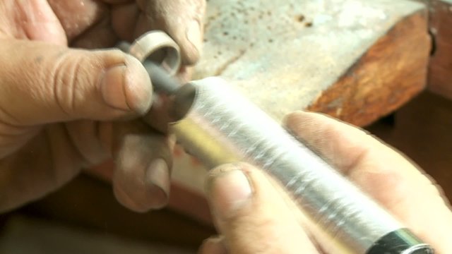 Goldschmied poliert Ring