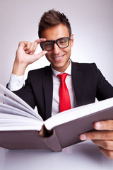 business man fixing his glasses while reading