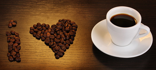 Cup of coffee on wooden table on brown background
