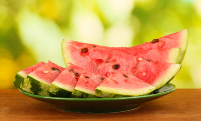 Slices of watermelon on the plate on green background close-up