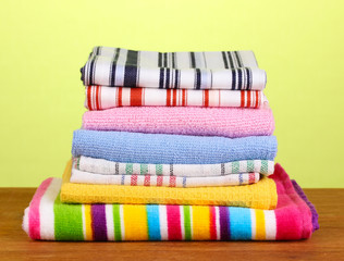 kitchen towels on wooden table on green background close-up