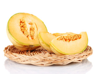 cut melon on wicker mat isolated on white