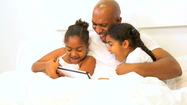 African American Parent Playing Bed Wireless Technology