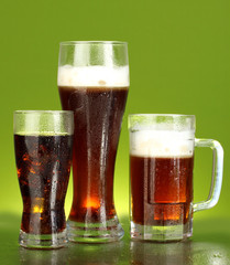 refreshments - beer, cola and kvass on green background