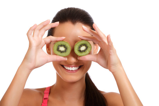 funny portrait of a young brunette woman with kiwi