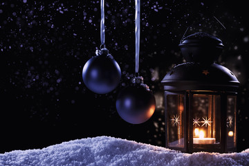 laterne im schnee mit christbaumkugeln und blauen lichteffekten