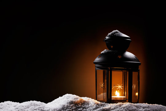 laterne in der dunkelheit steht im schnee