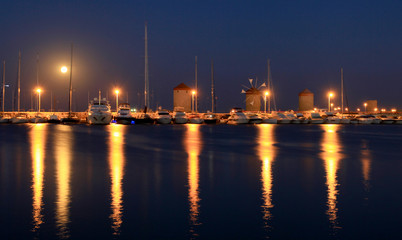 Rhodes harbor and windmills in Greece at sunset