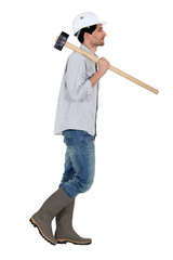 Profile of worker carrying sledge hammer