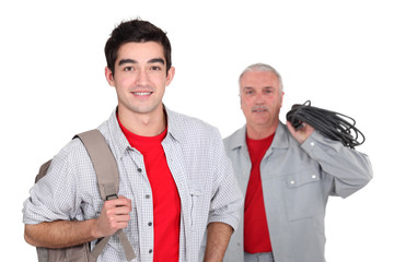 apprentice with backpack and senior workmate in background