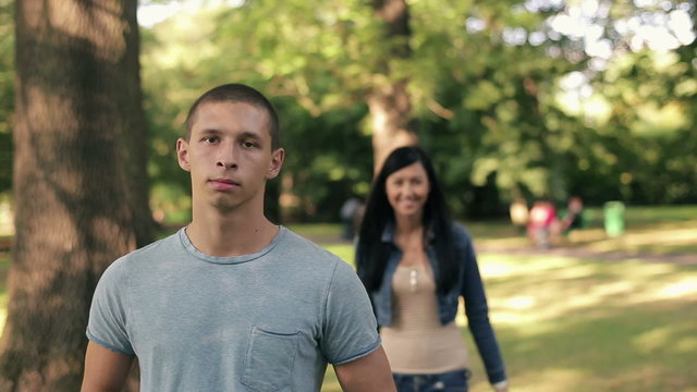 Happy teenage couple in love in the park, steadicam shot 
