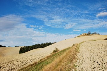 Fototapeta na wymiar rudere nella campagna toscana con cielo azzurro e nubi