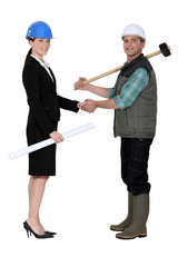 Businesswoman shaking the hand of a tradesman