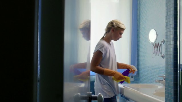 Young Woman Doing Chores And Cleaning Bathroom At Home