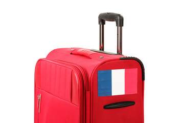 red suitcase with sticker with flag of France isolated on white