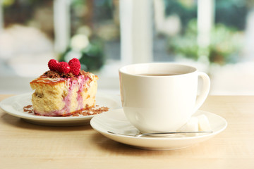 sweet cake with cup of tea on wooden table