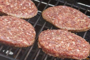 Raw  Burgers on a Barbecue