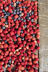 wild strawberry and bilberry  are on the wooden table