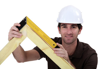Man using setsquare on wooden frame