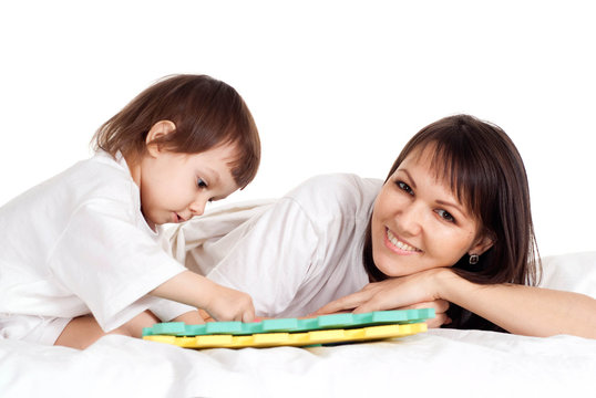 A beautiful mama with her daughter play with a mat