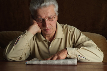 Beautiful Caucasian senior man sitting on a sofa
