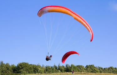 Multiple paragliders soar in the air amid wondrous landscape
