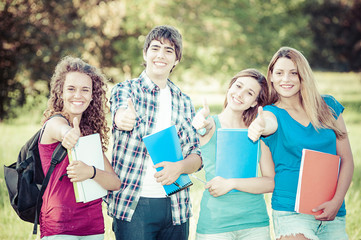 Young group of happy students showing thumbs up sign together ou