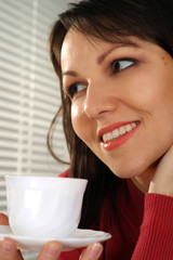 Pretty Caucasian woman standing with a cup
