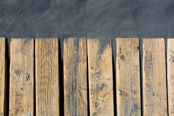 Black beach sand and wooden floor