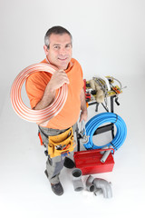 Plumber holding copper piping with various other materials