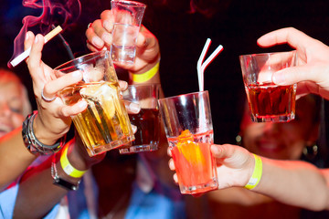 Celebration. Hands holding the glasses of cocktail and vodka mak