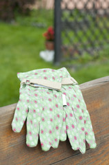 Green garden gloves on bench