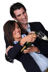 Happy couple pouring champagne