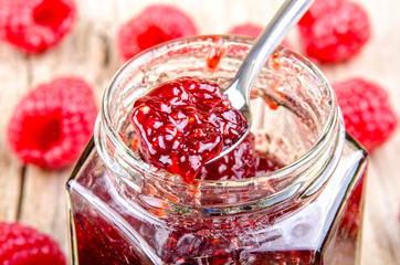 home made raspberry jam in a glass with a spoon