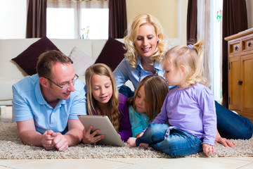Familie spielt mit dem Tablet computer daheim