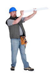 Builder looking through rolled plans