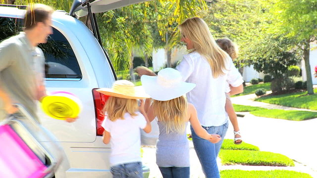 Young Family Packing Car for Trip to Beach