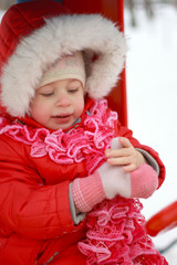 Beautiful baby playing on snow in winter