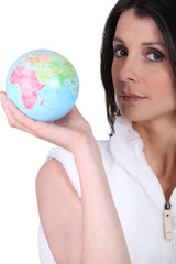 Brunette holding miniature globe