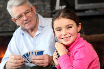 Young girl playing cards with grandpa