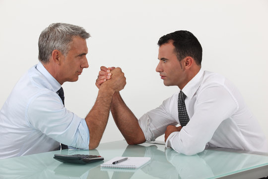 Businessmen arm wrestling